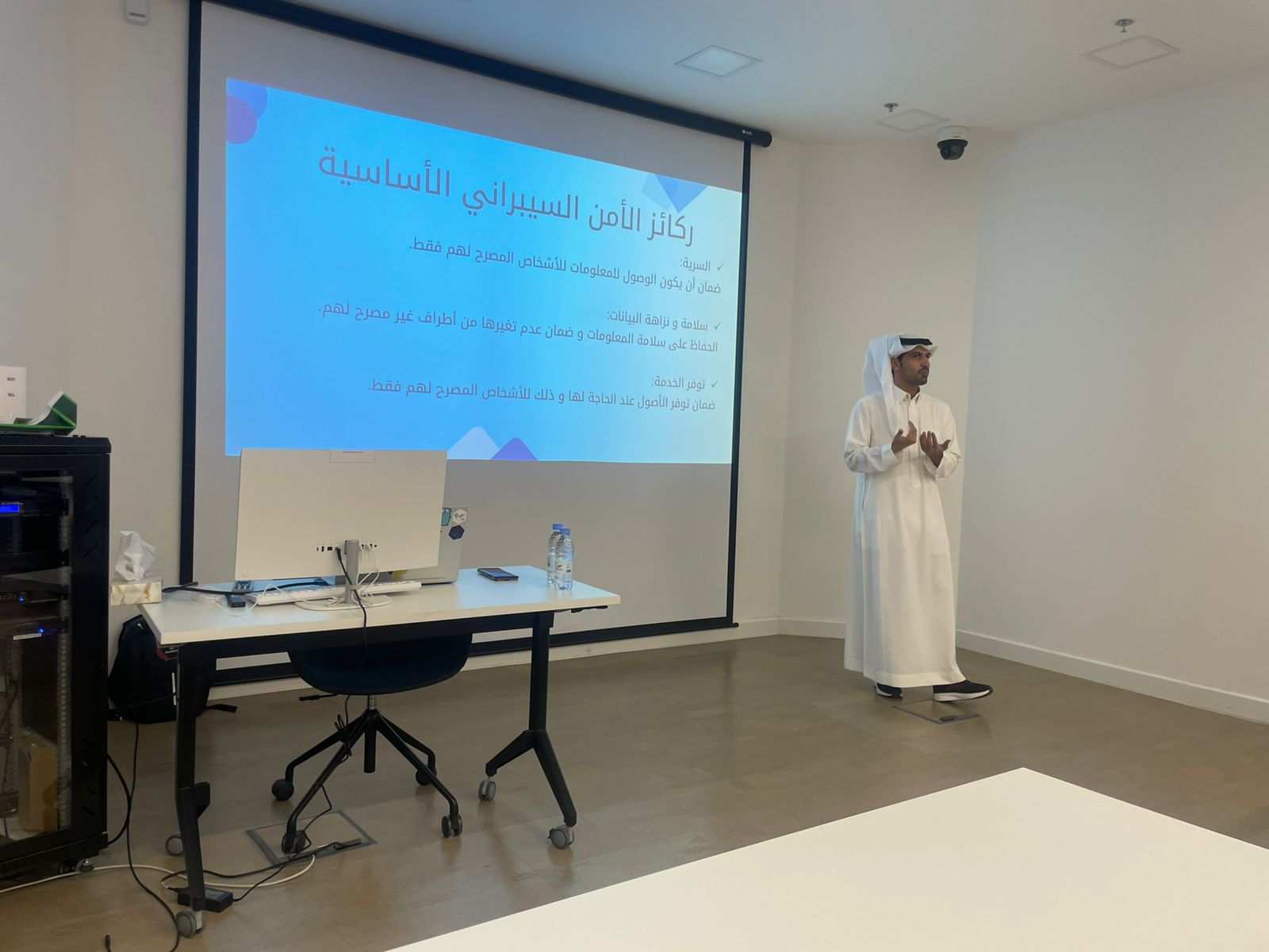 صورة للمهندس حمدان واقفا أمام البروجيكتور يشرح إحدى نقاط الورشة